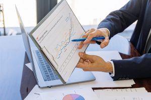 business man holding up a chart and pointing to it during a discussion